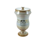 Jarrón decorativo de cerámica con tapa, presenta un diseño elegante en tonos beige y dorado, adornado con un patrón geométrico en la parte central. Ideal para decoración de interiores.