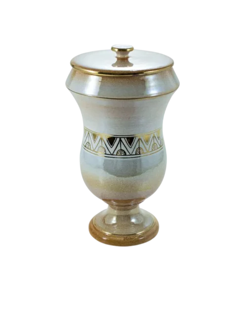 Jarrón decorativo de cerámica con tapa, presenta un diseño elegante en tonos beige y dorado, adornado con un patrón geométrico en la parte central. Ideal para decoración de interiores.