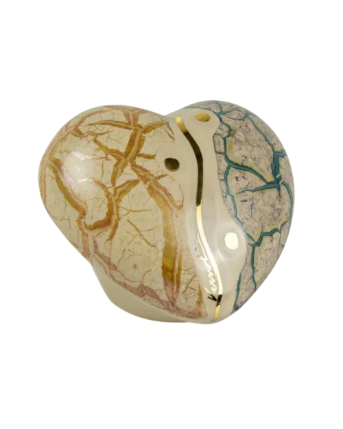 Piedra decorativa en forma de corazón con vetas doradas y azules, ideal para coleccionistas y decoración de interiores.