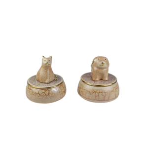 Figuras decorativas de cerámica que representan un gato y un perro, con detalles dorados y bases de diseño agrietado. Perfectas para adornar espacios interiores.