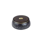 Caja decorativa de cerámica negra con un diseño agrietado y tapa marrón, adornada con un detalle dorado en forma de gota. Ideal para almacenamiento y decoración de interiores.