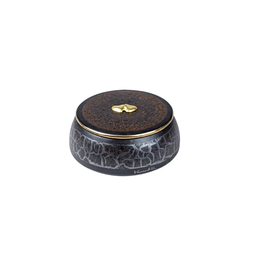 scatola marmo nero cuore A-Photoroom Caja decorativa de cerámica negra con un diseño agrietado y tapa marrón, adornada con un detalle dorado en forma de gota. Ideal para almacenamiento y decoración de interiores.